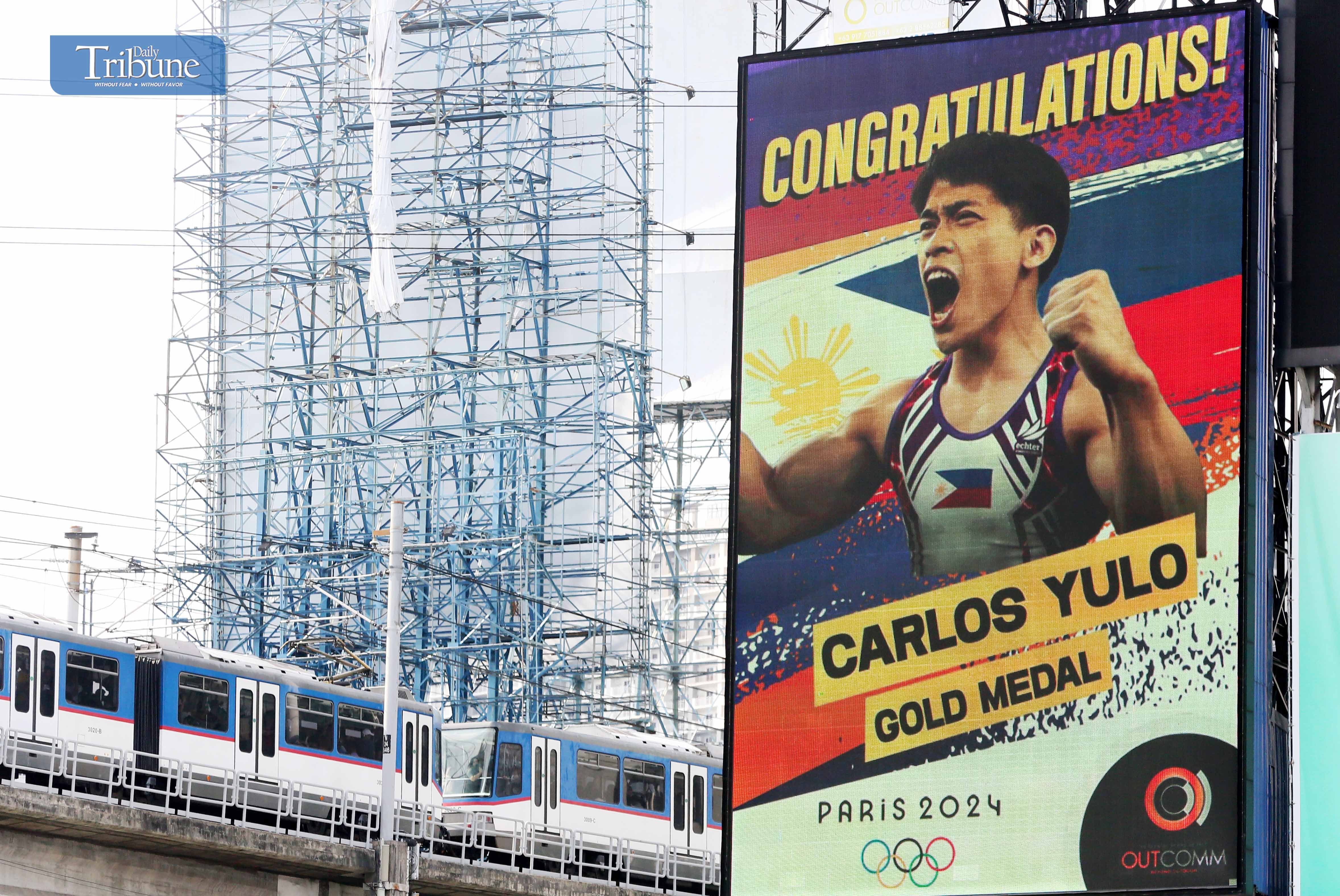 LOOK: A digital billboard along EDSA in Mandaluyong City on Sunday, 4 August 2024, displays a congratulatory message to Filipino gymnast Carlos Yulo, who won the country's first Olympic gold medal in men's artistic gymnastics floor exercise at the Paris Olympics on 3 August.